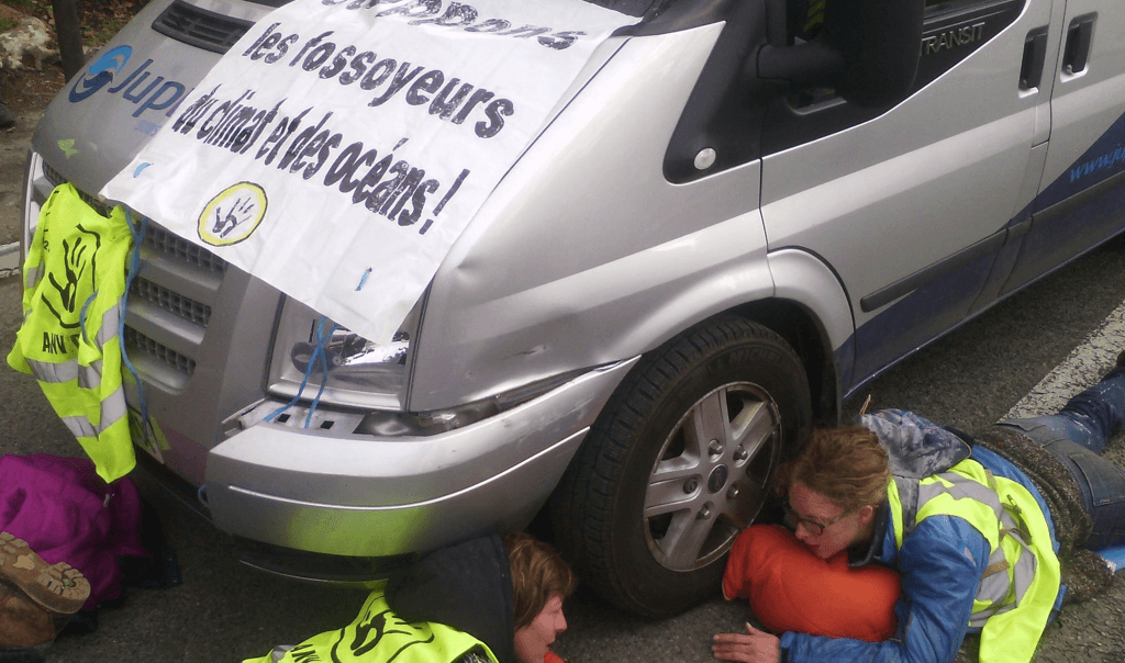 Deux activistes immobilisent un camion logistique à l'entrée du MCEDD en bloquant leurs bras sous le véhicule