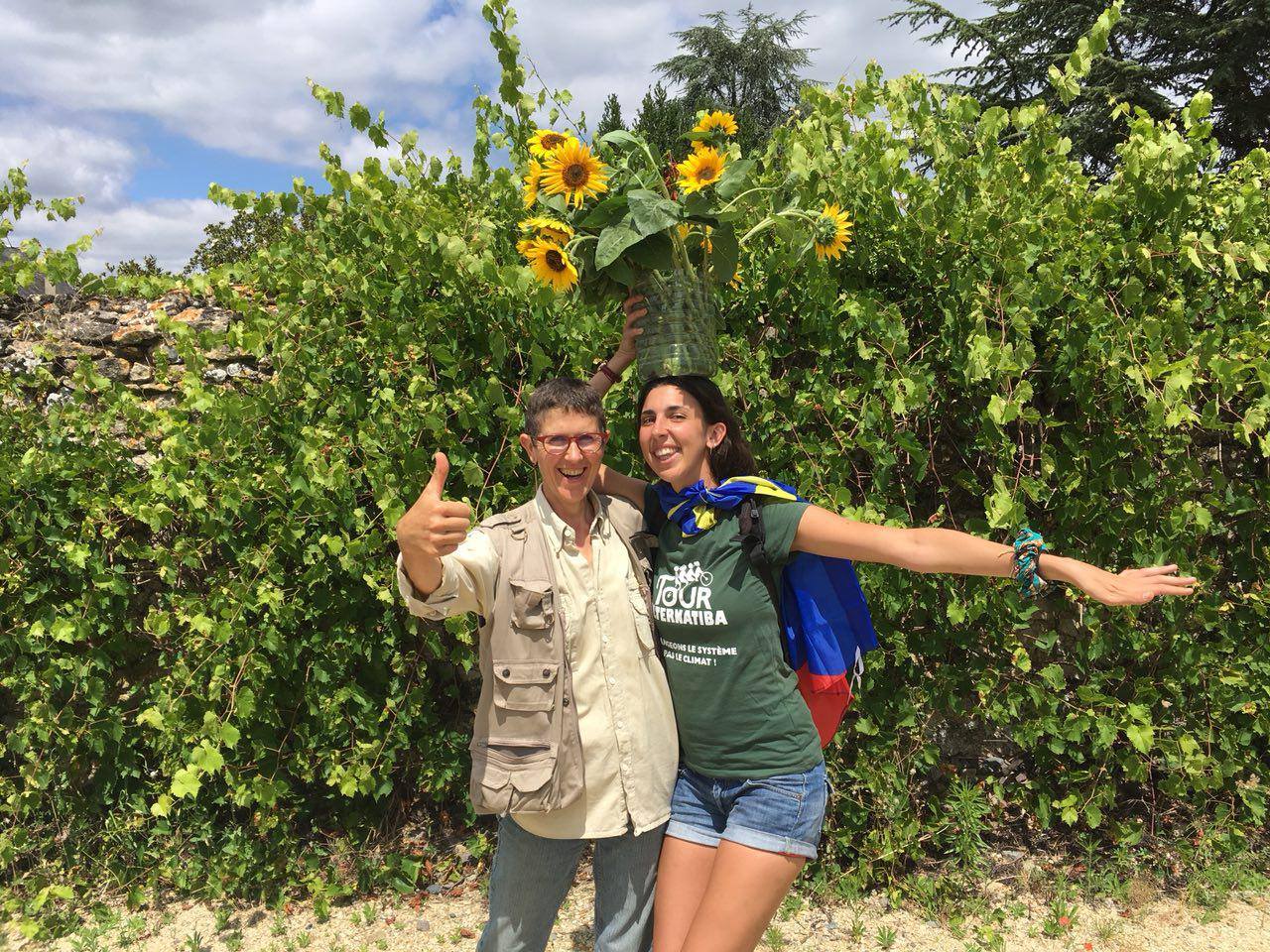 Tanika tient un vase de tournesol sur sa tête