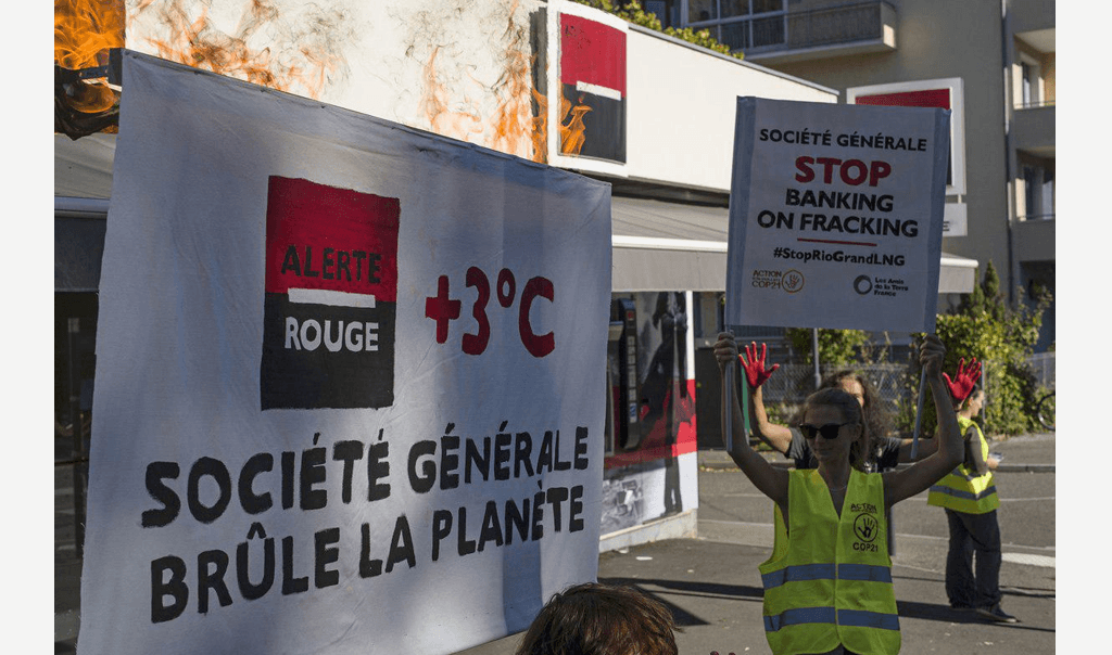 Des personnes se mobilisant devant une banque "Société Générale" avec des affiches "Société Générale brûle la planète", "STOP Banking on Fracking"