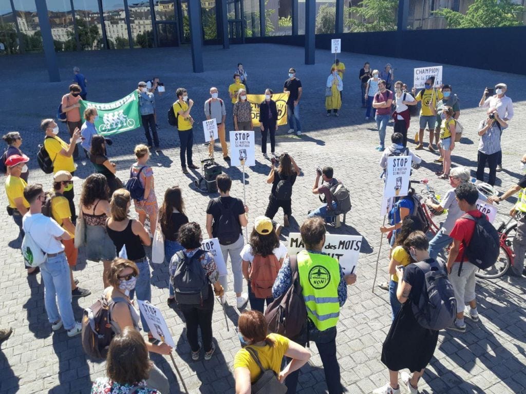 Militants climat entourent les citoyens en procès sur la place du tribunal