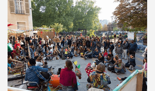Groupe de personnes en cercle écoutant des musiciens jouer