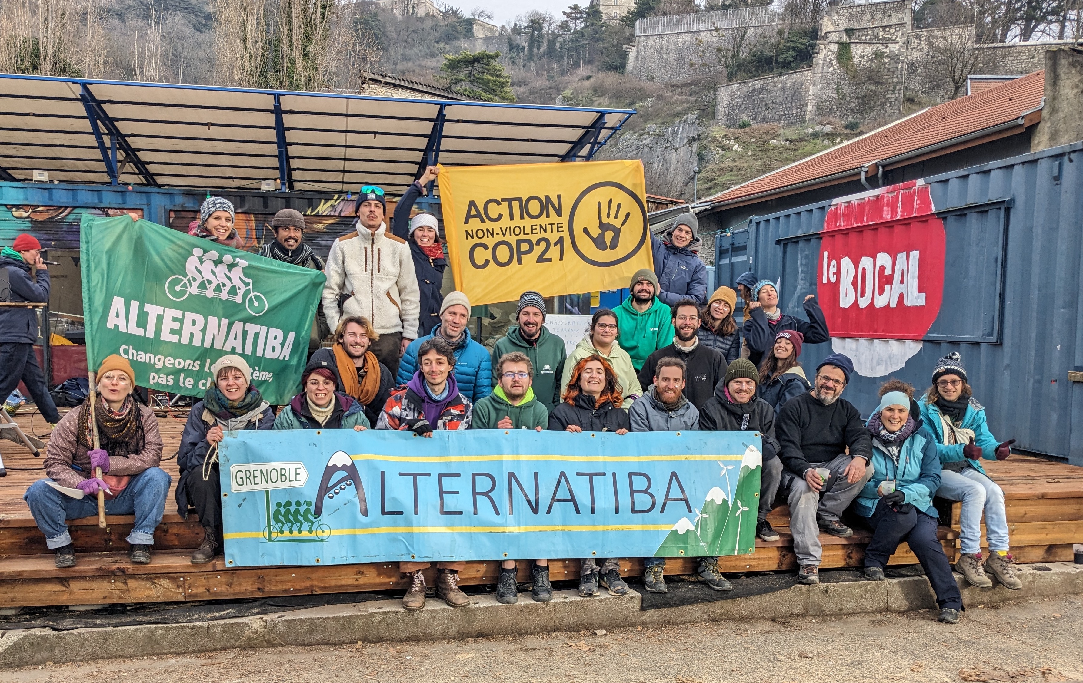 Un groupe de militant·es climat devant la Base de Grenoble avec des banderoles